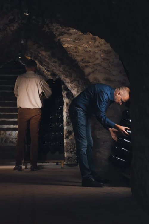 Des hommes examinent des bouteilles de champagne.