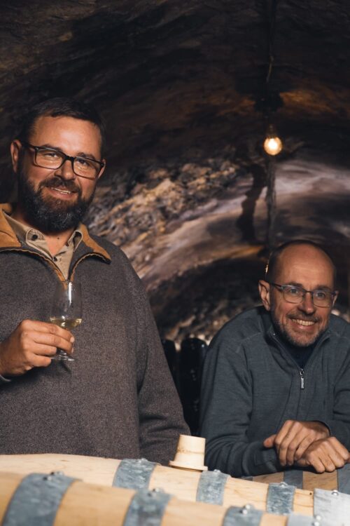 Deux hommes tenant des verres à vin lors d’une dégustation.